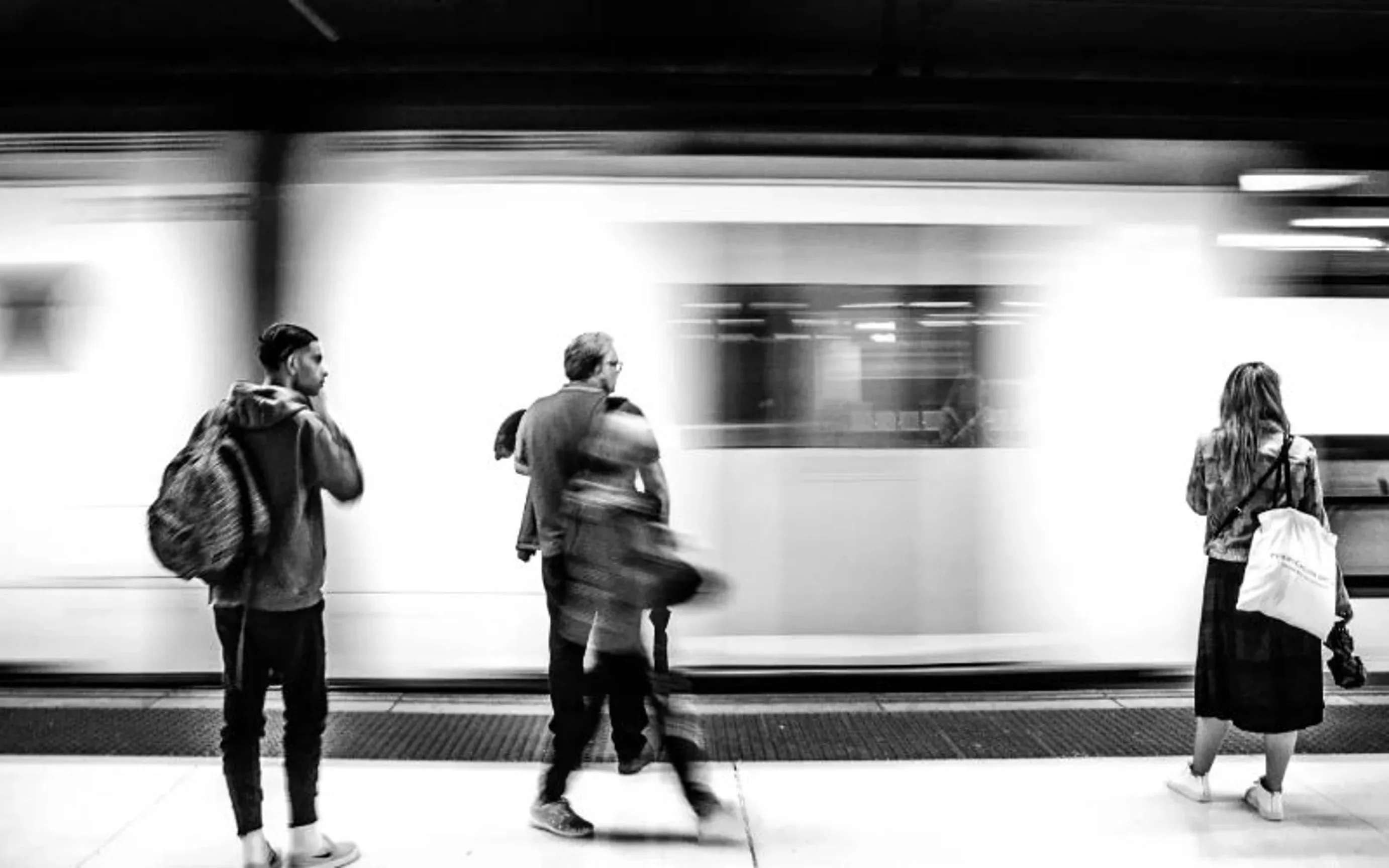 People waiting by a moving subway.