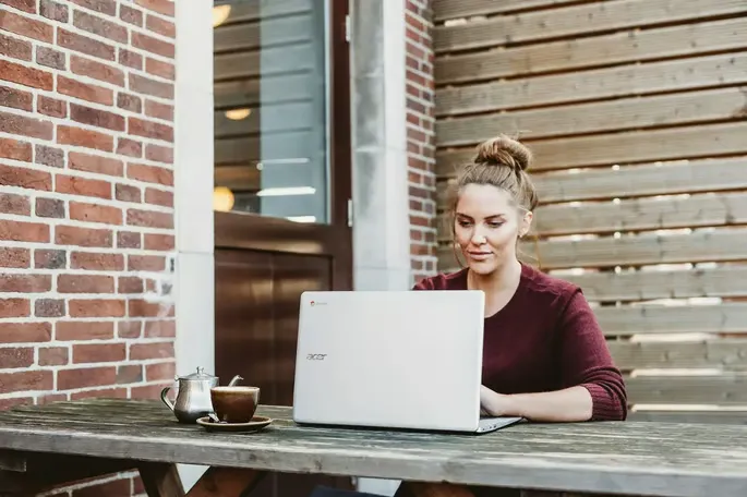 Woman searching on computer how to use an AI rewriter.
