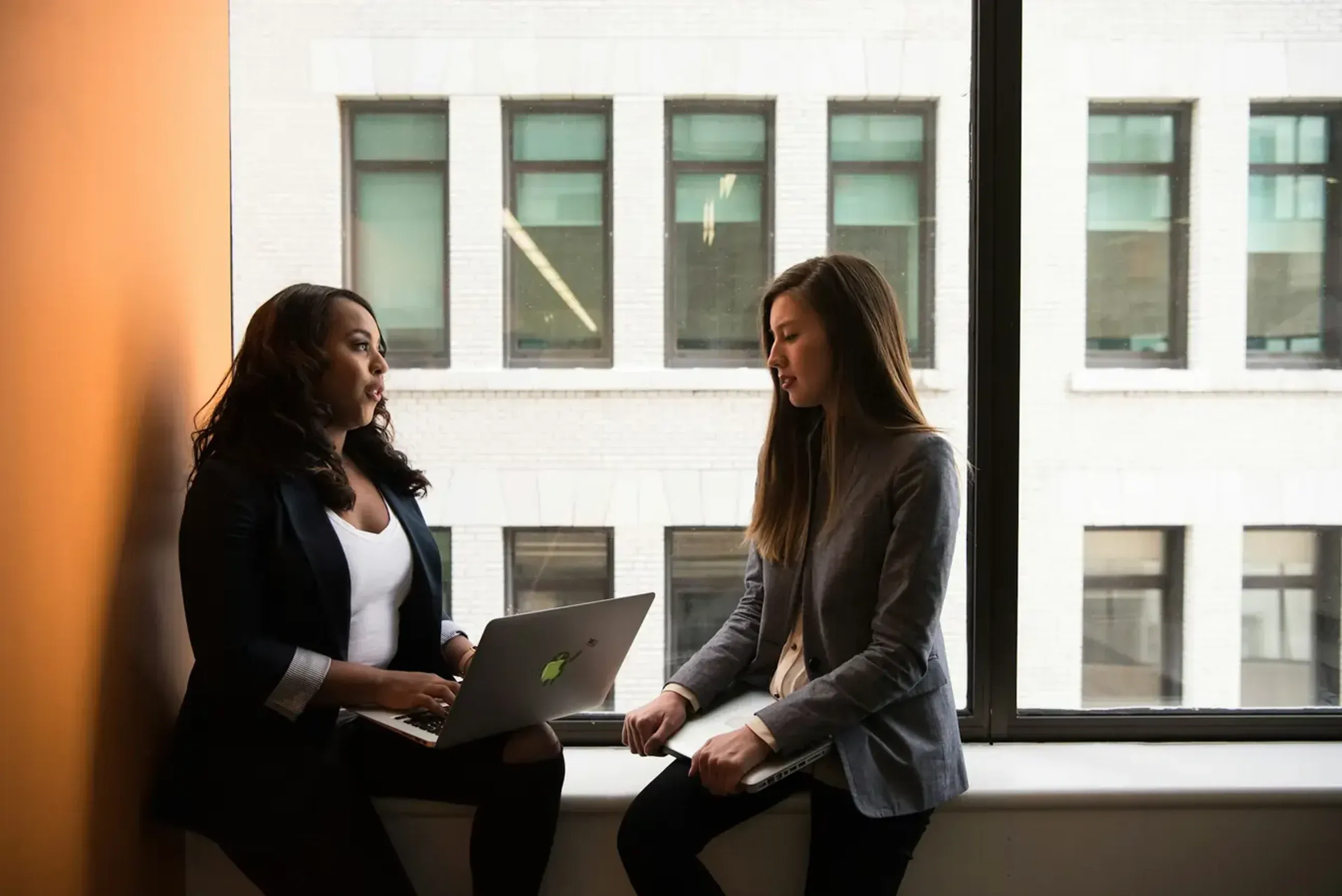 Two women professionals using undetectable AI on computer.
